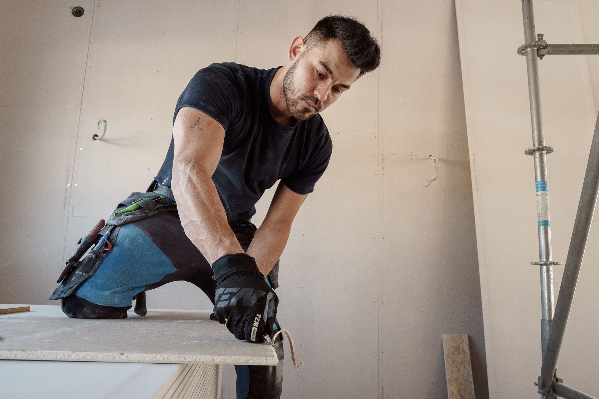 Profissional cortando placa de gesso em uma obra